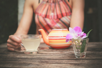 Young woman drinking tea at table