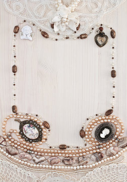 The vertical frame of female ornaments on a light wooden backgro