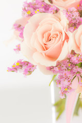 Peach roses and statice in a glass vase