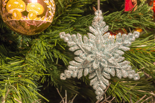 Bright Silver Six Point Star Decoration On Christmas Tree