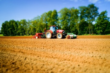 Obraz premium Getreideaussaat - Traktor mit Säkombination, Miniaureffekt