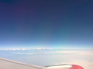 Naklejka na ściany i meble Blue sky with Himalayas range and airplane wings