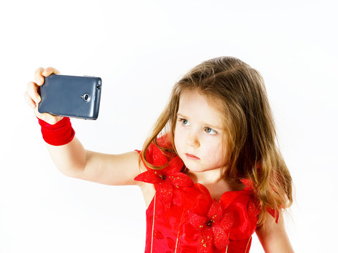 Cute  little ballerina dressed in red  taking a selfie photo