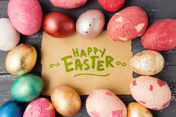 Easter eggs on wooden table with happy easter lettering. Holiday