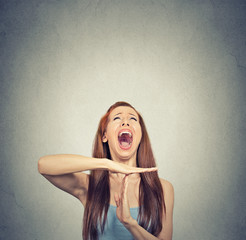 Young woman showing time out hand gesture frustrated