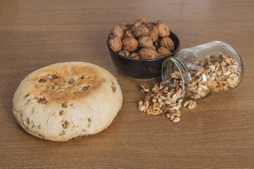 Bread, nutcracker and walnuts in a wooden table