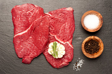 Raw beef steak on a black chalkboard