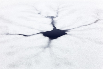 Cracks and black hole in floating ice on water of pond