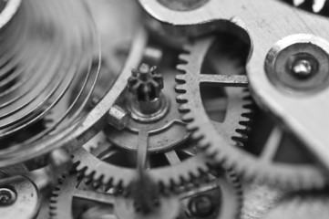 Black and white background with metal cogwheels inside clockwork