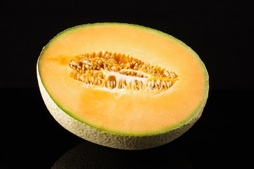 Cantaloupe melon fruit with reflection on the black background