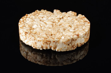Buckwheat cracker on the black background with reflection