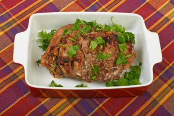 A large piece of veal pork cooked in the oven with a ceramic bak