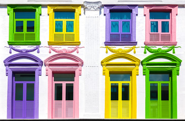 Colorful windows in white building facade.