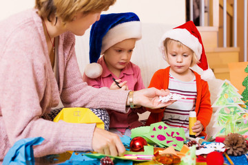 woman helping  girls to make decoration for Xmas