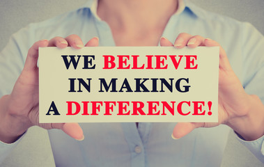 Businesswoman hands sign We Believe in Making a Difference 