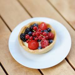 Custard fruit tart on white plate