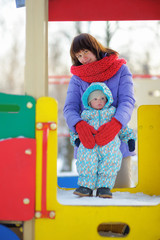 Toddler boy with his mother on playground
