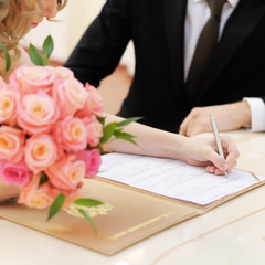Obraz na płótnie Canvas Bride signing marriage license