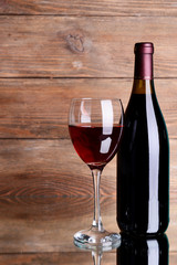 Red wine on table on wooden background