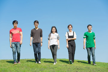 Happy group of students walking and talking at the park