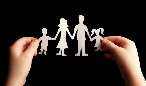 Paper Family In Child Hands On Black Background