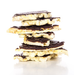 Pieces of chocolate coated rice cakes on white background