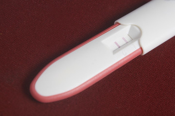 Pregnancy Test Pack At Dark Red Background