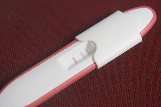 Pregnancy Test Pack At Dark Red Background