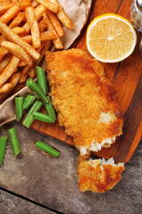 Breaded fried fish fillet and potatoes with asparagus and lemon