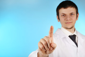 Doctor working with virtual screen on blue background