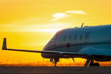Business jet on the apron of aircraft. Dawn at airport