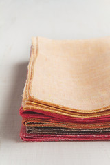 Stack of hand made colorful napkins on white background