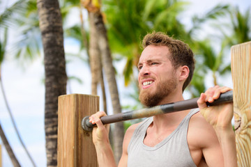 Crossfit man working out pull-ups on chin-up bar