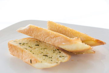 Garlic and herb bread on white plate.
