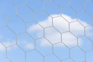 Soccer goal net in soccer stadium and blue sky.