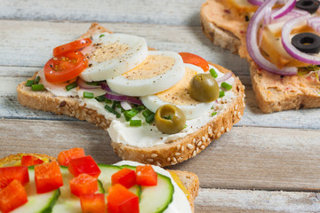 Fototapeta na wymiar Sandwiches on wooden background, closeup