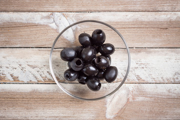 Bowl of blueberries on wooden background, top view