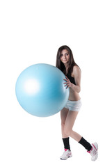 Young athletic woman with blue exercise ball