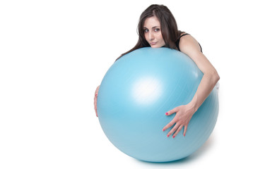 Young athletic woman with blue exercise ball