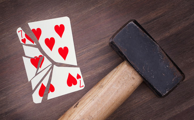 Hammer with a broken card, seven of hearts