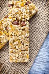 Muesli bars, cereal bars on the wooden background.