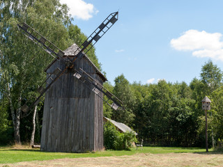 Old wooden windmill on background of blue sky