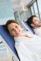 Couple relaxing in spa center longchairs © goodluz