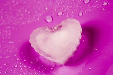 Valentines greeting card with ice heart on pink background