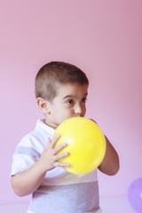 Fototapeta na wymiar Boy blowing up a balloon