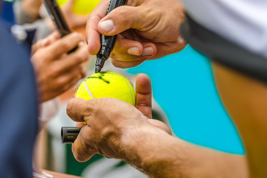 Tennis player signs autograph after win