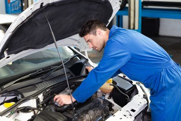 Fototapeta premium Mechanic examining under hood of car