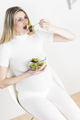 portrait of pregnant woman eating vegetable salad