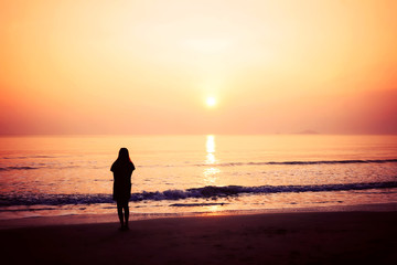 Fototapeta na wymiar silhouette of woman alone and wave on the beach