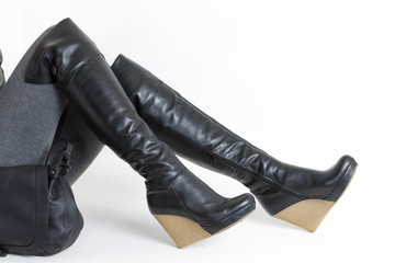 detail of sitting woman wearing platform black boots with a hand